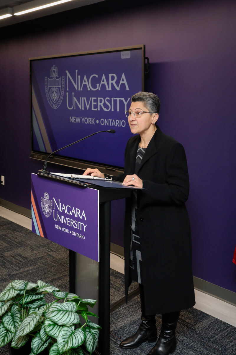 Stephanie standing at a podium presenting