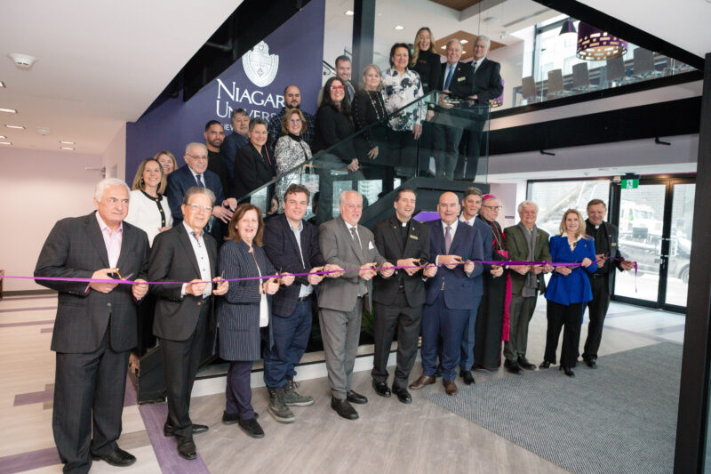 People standing on stairs and more people standing on the side holding a purple ribbon