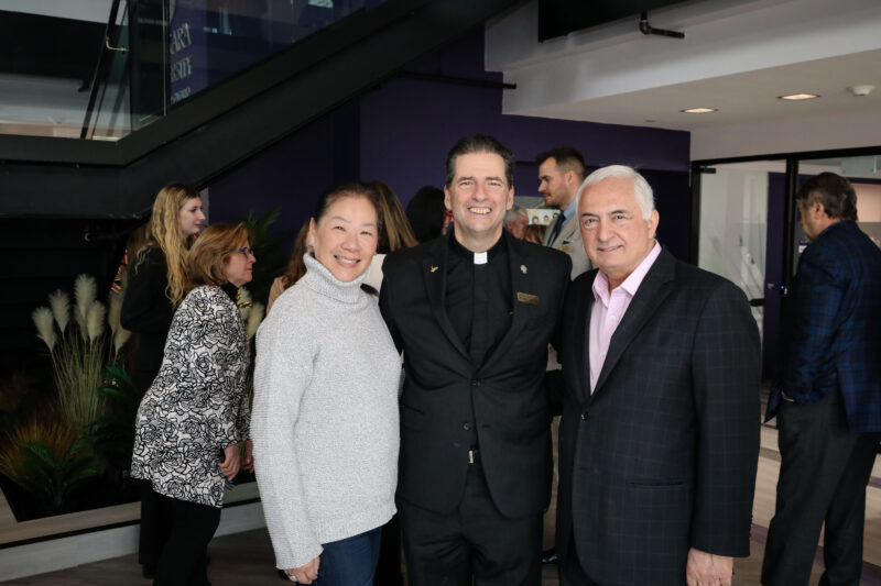 Father Maher standing with two people at the ribbon cutting for the New Vaughan Campus