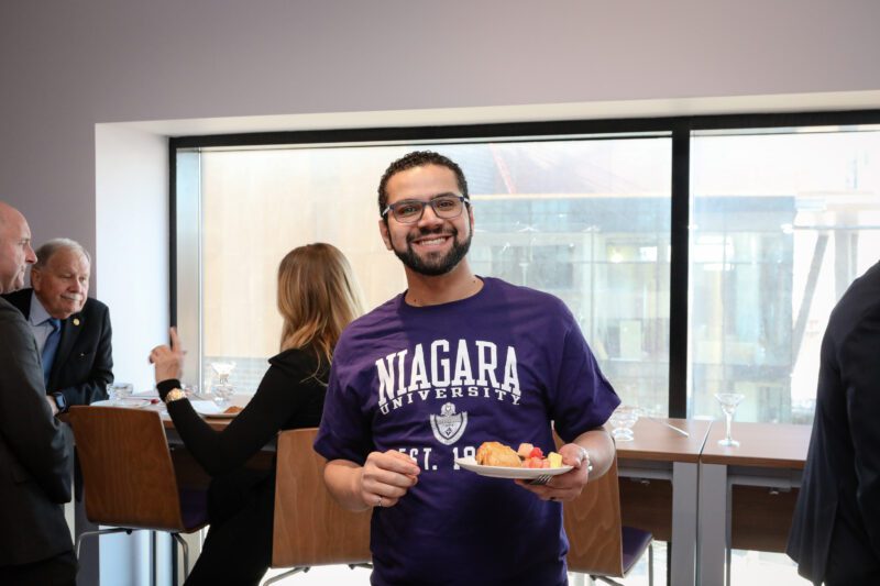 Student smiling holding a plate of food