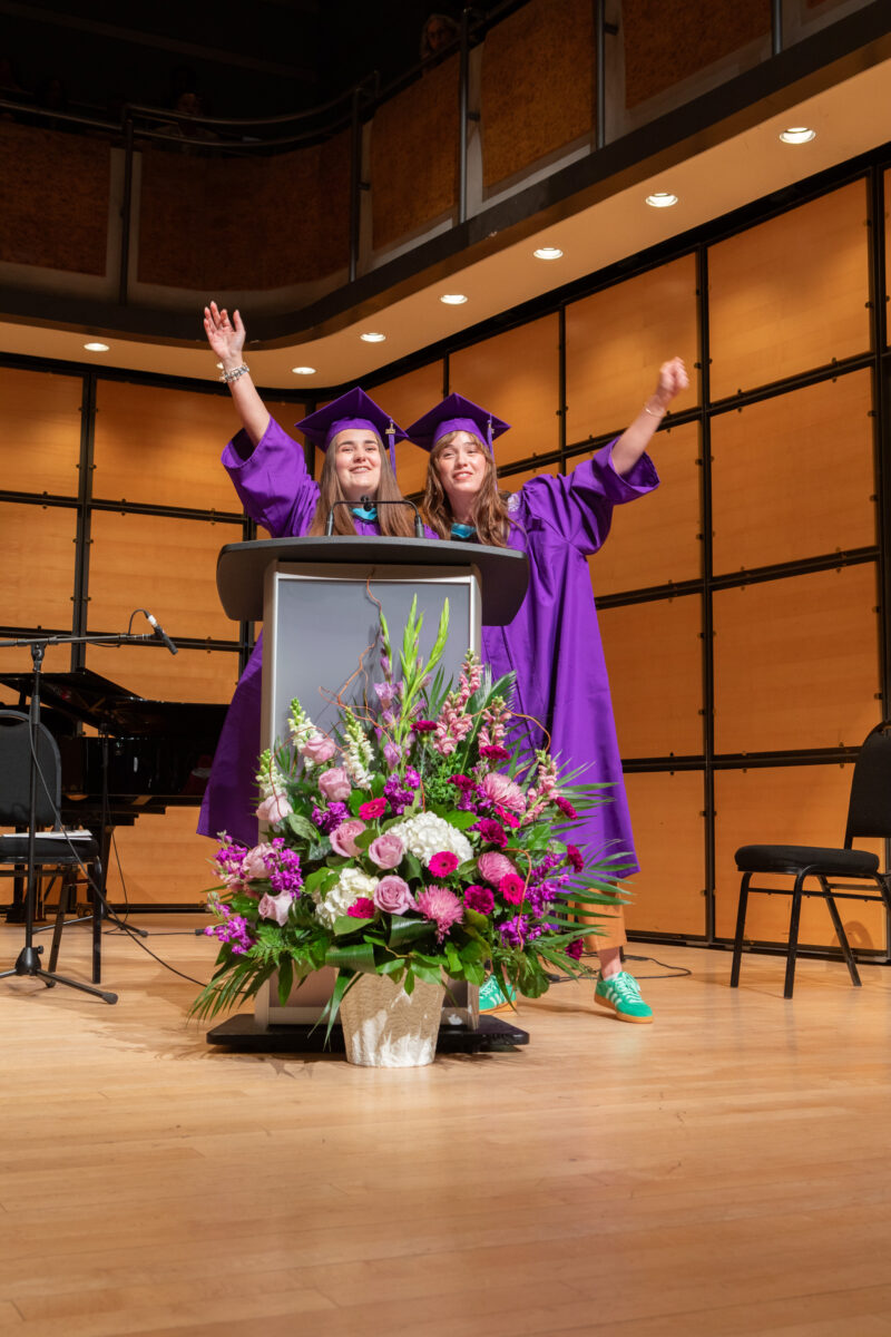 graduating students celebrating at podium
